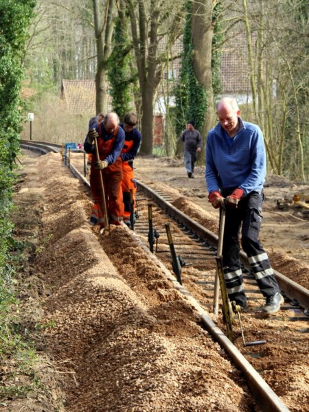 066 Da die Witterung die Herstellung eines vernünftigen Planums verhindert hat müssen wir jetzt per Hand ran. Klaus, Jens  und Lionel unterfüttern das grob in der Höhe ausgerichtete Gleis.<br />Foto Regine M.