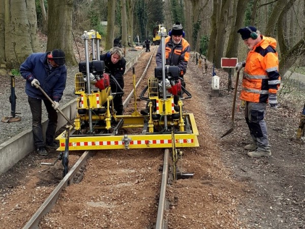 117 Die letzten Schwellen! Alex und Robert stopfen den Anschluß zum alten Gleis, unterstützt von Konrad und Kalle.<br />Foto Klaus E.