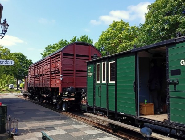 002 Es wird aber kein reiner Personenzug, wie am Bahnsteig zu sehen ist. Der Viehwagen DEV Gw 8 auf Rollböcken und der Zwischenwagen 162 machen den Zug zu einem PmG.<br />Foto Eike A.